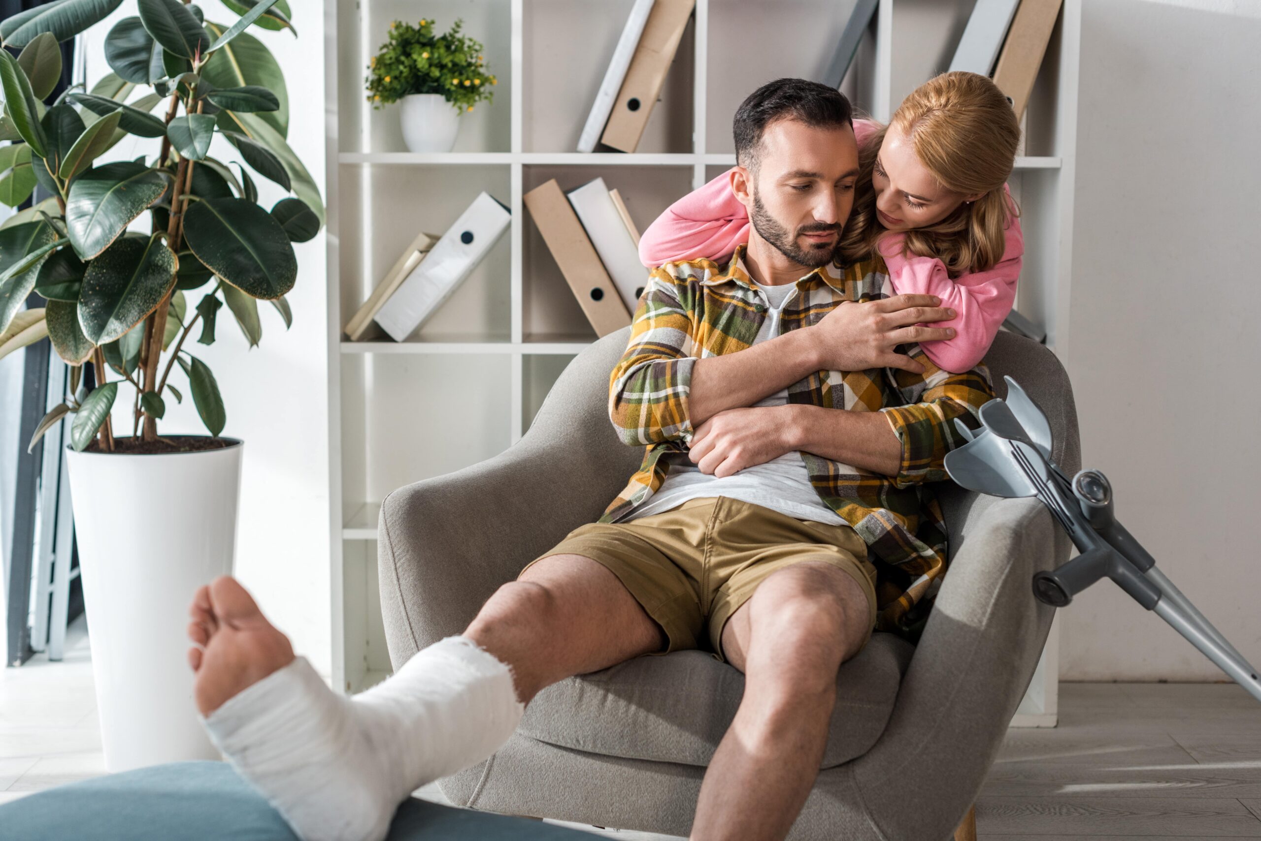 Woman offering comfort by hugging her injured partner at home